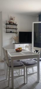 a white dining room table with chairs and a television at Apartman Vida in Zaton
