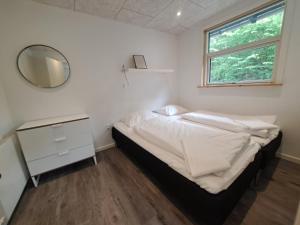 a small bedroom with a bed and a mirror at Byhus i Glyngøre in Glyngøre +21 photos