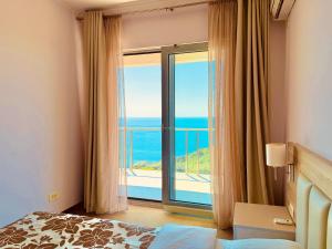 a bedroom with a large window with a view of the ocean at Tophill Altezza 9 Breathtaking Views and Terrace in Budva