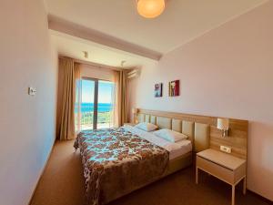 a bedroom with a bed and a large window at Tophill Altezza 9 Breathtaking Views and Terrace in Budva