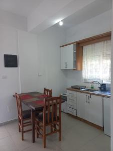 a kitchen with a table and chairs in a kitchen at Anna! in Ksamil