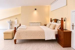 a bedroom with a large bed and a dresser at Spacious Villa near Porto - BBQ and Private Parking in Vila Nova de Gaia