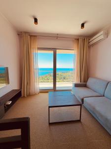 a living room with a blue couch and a large window at Tophill Altezza 9 Breathtaking Views and Terrace in Budva