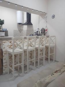 a kitchen with a white counter with stools at Oni Guesthouse in Oni