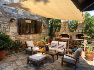 an outdoor patio with chairs and a stone fireplace at Kamarca House Hotel in Ortaca