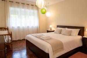 a bedroom with a bed with white sheets and a window at Spacious Villa near Porto - BBQ and Private Parking in Vila Nova de Gaia +33 photos