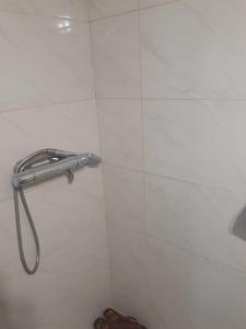 a shower in a white tiled bathroom with a toilet at Oni Guesthouse in Oni