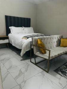 a bedroom with a bed and a couch and a chair at Rest Easy Guest House Pty Ltd Unit 5 in Boksburg +16 photos
