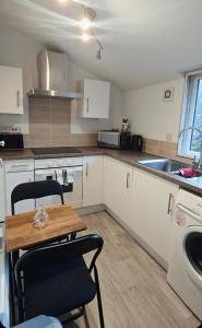 a kitchen with a table and chairs and a sink at 1 bed flat, free parking, canalside, sleeps 2 in Hertford