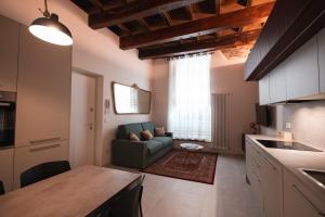 a kitchen and a living room with a couch at J&B Imola Home in Imola