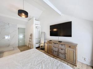 a bedroom with a flat screen tv on a wall at Charmante maison in Namur