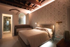 a bedroom with a bed and a chair and a window at J&B Imola Home in Imola