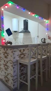 a kitchen with a white counter with lights on it at Oni Guesthouse in Oni