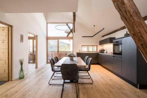 eine Küche und ein Esszimmer mit Tisch und Stühlen in der Unterkunft Bachmannhof in Feldthurns