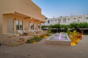 ein Gebäude mit einem Brunnen vor einem Gebäude in der Unterkunft Fragiskos Hotel in Matala