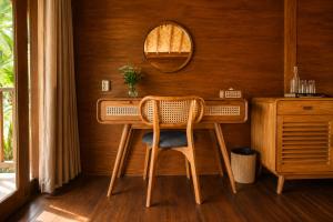 a wooden table with a chair and a mirror at The Payung House - Romantic Riverside Villa in Bebandem +30 photos