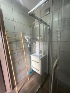 a bathroom with a glass shower with a sink at Domki Teo - Rewal in Rewal +99 photos