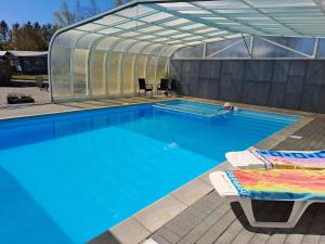 a swimming pool with a greenhouse and a swimming pool at Byhus i Glyngøre in Glyngøre