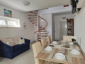 a dining room with a table and a blue couch at Csengi Apartman in Balatonszárszó
