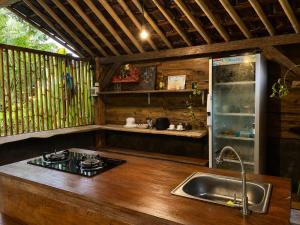 a kitchen with a sink and a counter top at The Payung House - Romantic Riverside Villa in Bebandem