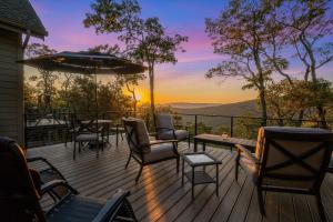 a deck with chairs and tables and an umbrella at Art & Soul Main House in Lyndhurst