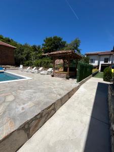 a patio with a gazebo and a pool at Къща "Конакъ" in Ussoika