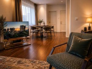 a living room with a tv and a table with chairs at Tallinn Residence 1937 in Tallinn
