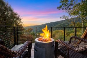 a fire pit sitting on a deck with two chairs at Art & Soul Main House in Lyndhurst