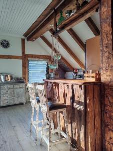 a kitchen with a wooden counter and chairs in a room at Timber loft in Vigra