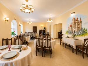 a restaurant with tables and chairs and a painting on the wall at Hotel Three Korony in Skhidnitsa