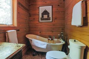 a wooden bathroom with a tub and a toilet at Bear Tracks Cottage in Nellysford