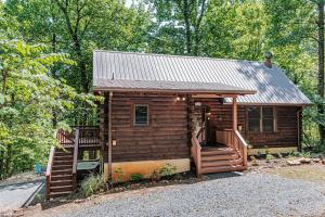 a cabin in the woods with a porch and stairs at Bear Tracks Cottage in Nellysford