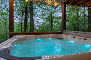 a jacuzzi tub in a room with trees at Bear Tracks Cottage in Nellysford