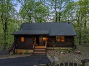 a log cabin in the woods with the door open at Bear Tracks Cottage in Nellysford