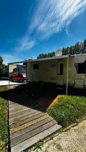 a yellow trailer parked next to a wooden ramp at Camping car Paris in Savigny-le-Temple