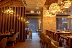 a restaurant with tables and chairs and chandeliers at Apart-hotel Pahulja in Jahorina +37 photos