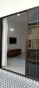 a living room with a sliding glass door with a television at Homestay Kamila Mersing in Mersing