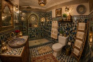 a bathroom with a toilet and a shower and a sink at Riad T-A-J Fès Crown in Fez