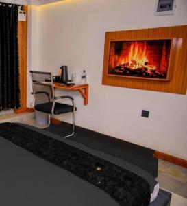 a room with a fireplace and a chair and a desk at Fortunas Resort Nkubu, Meru in Nkubu