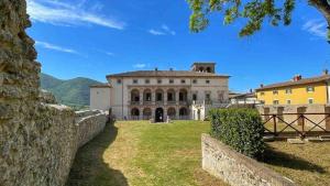 an old mansion with a stone wall in front of it at La Specola di Galileo con ampia vasca idromassaggio in Acquasparta