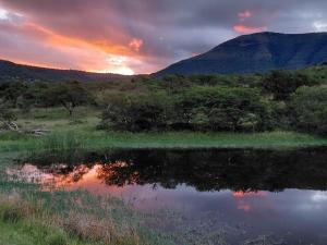 a sunset over a lake with a mountain in the background at Glen Avon Farm in Somerset East +18 photos