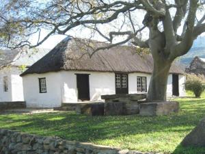 a large white house with a thatched roof at Glen Avon Farm in Somerset East
