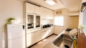 a kitchen with a white refrigerator and a sink at SORA Blue House, 海辺の隠れ家, ペットBBQ可, 全3寝室&リビングオーシャンビュー,一棟貸切 in Hokota