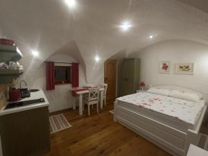 a bedroom with a bed and a kitchen and a table at Apartments Skok in Bled