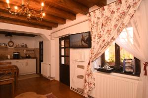 a living room with a window and a tv on the wall at Casa Lörinczi in Sighişoara