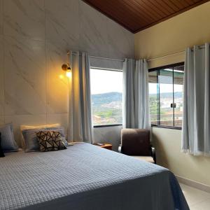 a bedroom with a bed and a large window at Pousada do Irlandês in Pirenópolis +51 photos