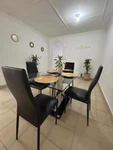 a dining room with a glass table and chairs at Guajira Sunset Hostal in Ríohacha +24 photos