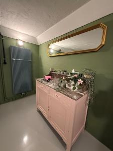 a bathroom with a pink sink with a mirror at Charmante Art Deco rijwoning in Ostend +37 photos