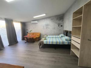 a bedroom with a bed and a chair in a room at Villa Topaz in Capoterra