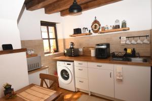 a kitchen with a sink and a washing machine at Casa Lörinczi in Sighişoara